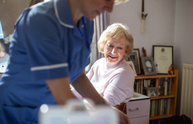 Nurse administering a blood pressure reading in the community