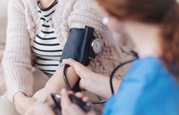 Image of healthcare professional taking blood pressure reading