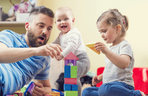 Adult playing bricks with children.