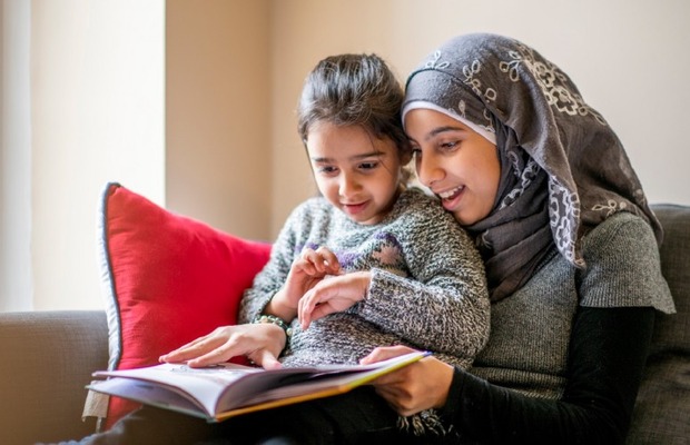 Image of child and adult reading together.