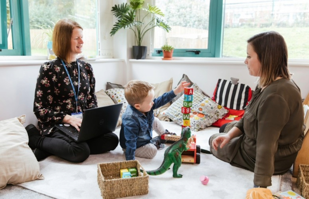 Toddler with parent and guardian playing with Healthcare Professional