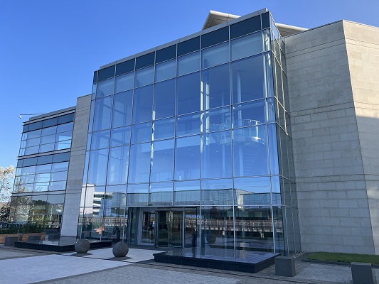 Glass fronted office block with blue sky