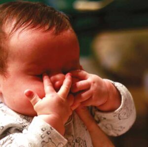 Baby with hands on their face
