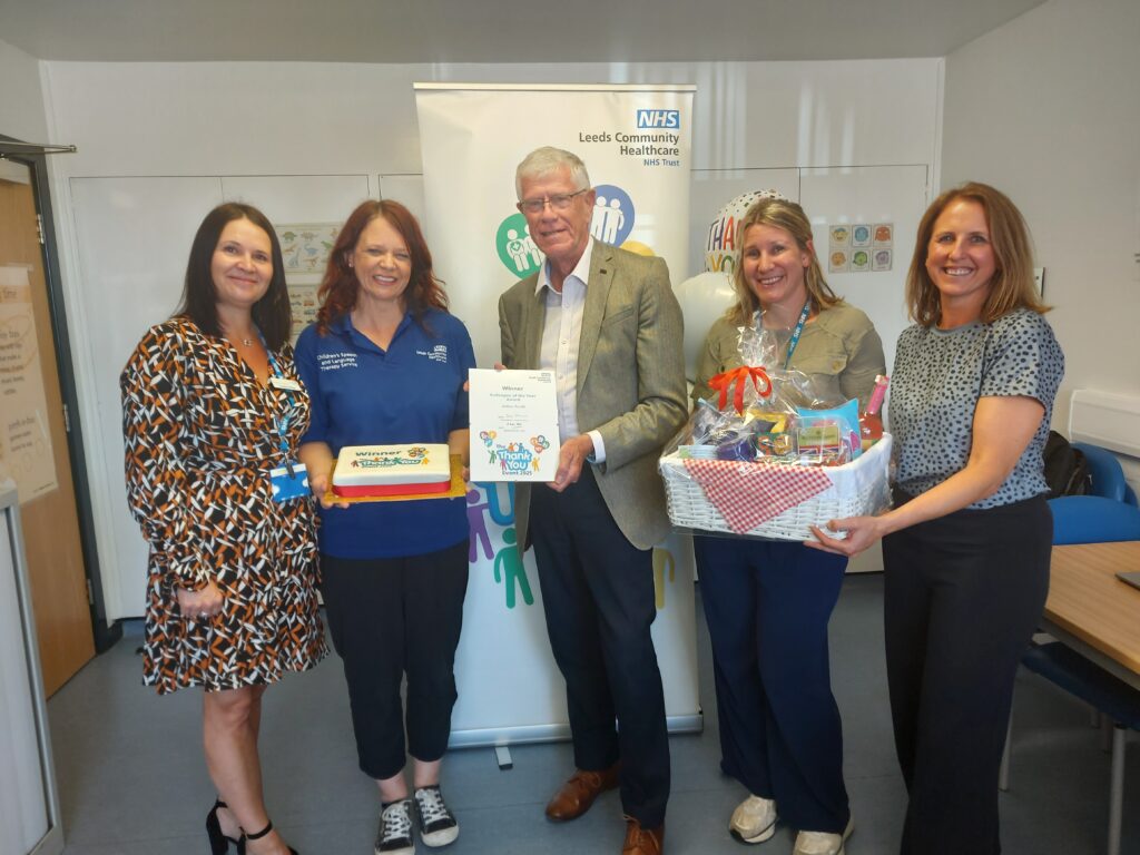 Brodie Clark CBE presents the Colleague of the Year winner Andrea Arnold a certificate, hamper and cake, here with the Speech and Language Therapy Team