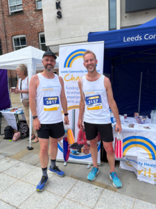 2 LCH employees in running clothes after the Leeds 10k at the LCH stall. 