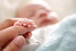 baby holding a parent's finger