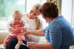 Health Visitor Talking To White British Mother With Young Baby