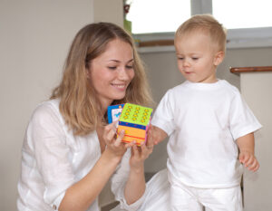 Young mother is playing with her little son