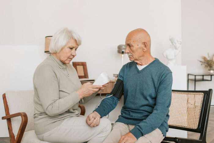 a woman helping a man check his blood pressure