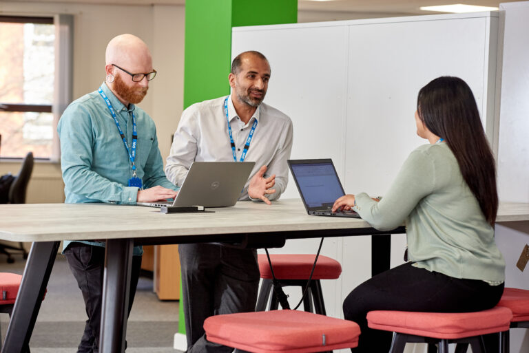 People working together at a shared desk area